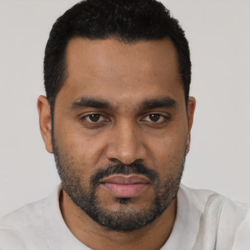 Joyful black young-adult male with short  black hair and brown eyes