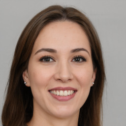 Joyful white young-adult female with long  brown hair and brown eyes