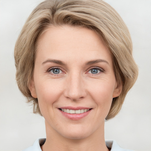 Joyful white young-adult female with medium  brown hair and green eyes