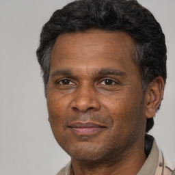 Joyful black adult male with short  black hair and brown eyes