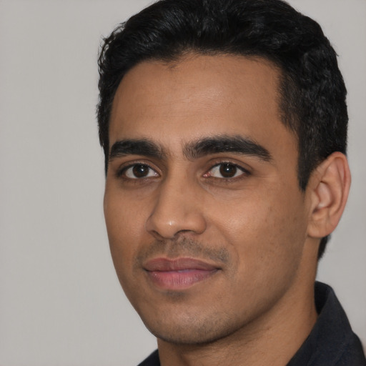 Joyful latino young-adult male with short  black hair and brown eyes