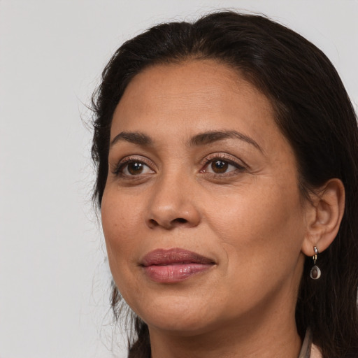Joyful latino adult female with long  brown hair and brown eyes