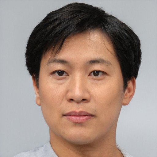 Joyful asian adult male with short  black hair and brown eyes