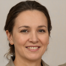 Joyful white adult female with medium  brown hair and brown eyes