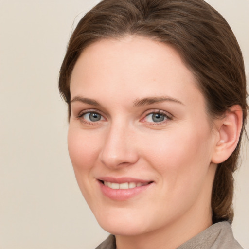 Joyful white young-adult female with medium  brown hair and grey eyes