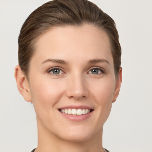 Joyful white young-adult female with short  brown hair and grey eyes