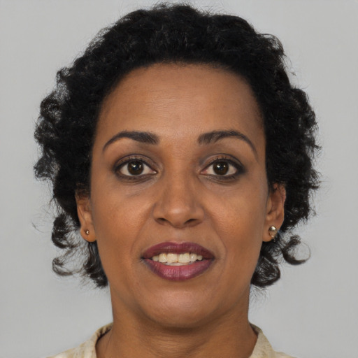 Joyful black adult female with short  brown hair and brown eyes