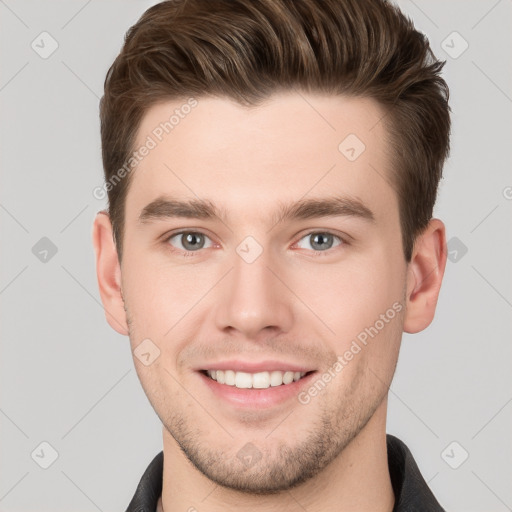 Joyful white young-adult male with short  brown hair and grey eyes