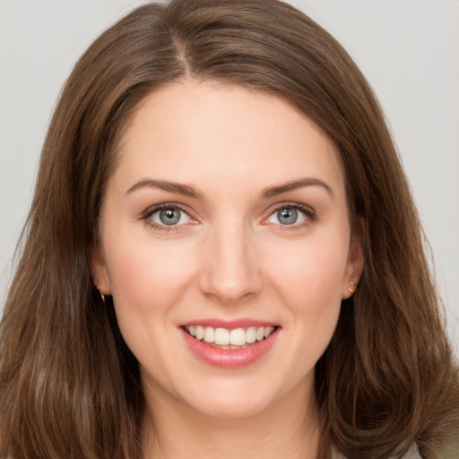 Joyful white young-adult female with long  brown hair and green eyes