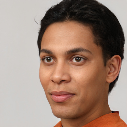 Joyful latino young-adult male with short  brown hair and brown eyes