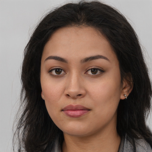 Joyful latino young-adult female with long  brown hair and brown eyes