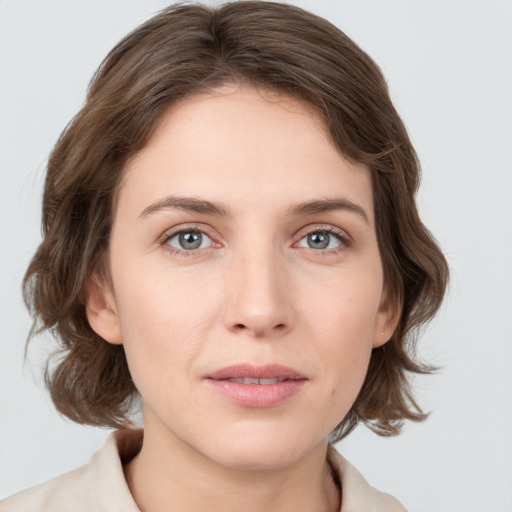 Joyful white young-adult female with medium  brown hair and grey eyes