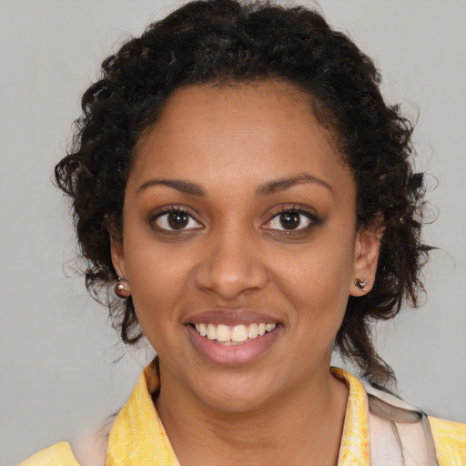 Joyful black young-adult female with medium  brown hair and brown eyes