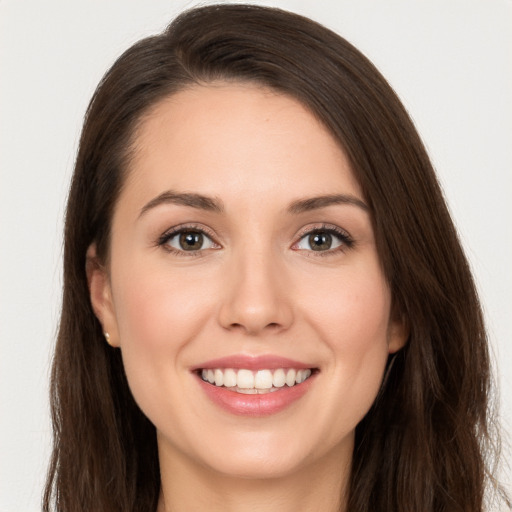 Joyful white young-adult female with long  brown hair and brown eyes