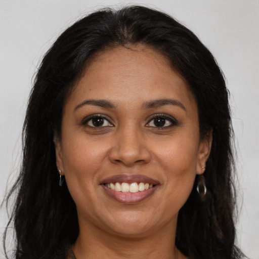 Joyful latino young-adult female with long  brown hair and brown eyes