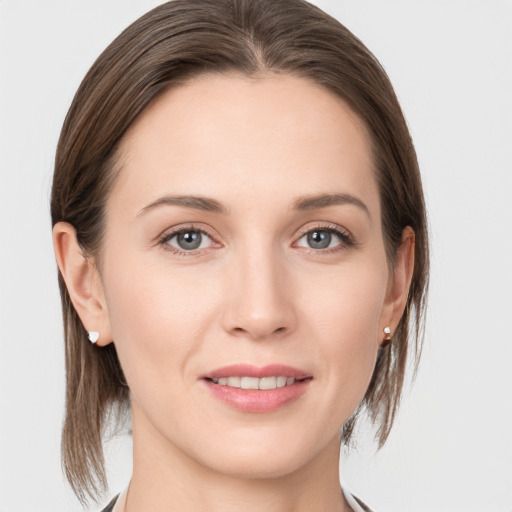 Joyful white young-adult female with medium  brown hair and grey eyes