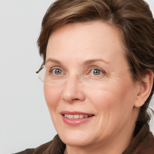 Joyful white adult female with medium  brown hair and grey eyes