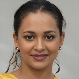 Joyful latino young-adult female with medium  brown hair and brown eyes