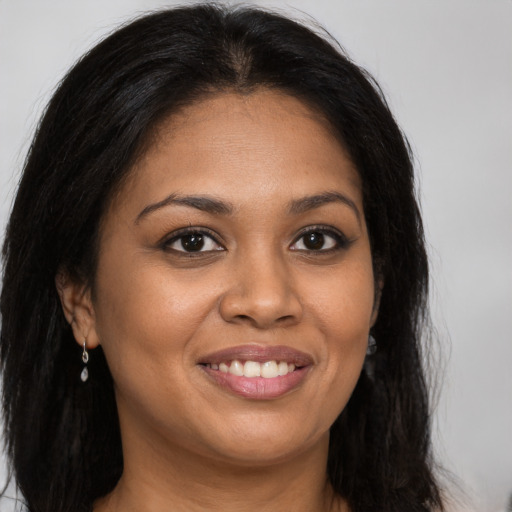 Joyful black young-adult female with long  brown hair and brown eyes