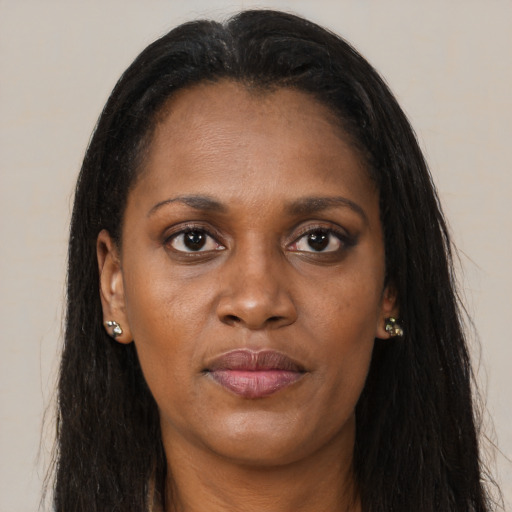 Joyful black young-adult female with long  brown hair and brown eyes