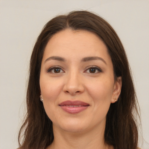 Joyful white young-adult female with long  brown hair and brown eyes