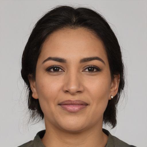 Joyful latino young-adult female with medium  brown hair and brown eyes