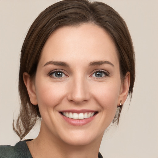 Joyful white young-adult female with medium  brown hair and grey eyes