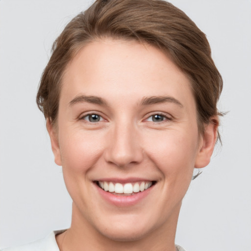 Joyful white young-adult female with short  brown hair and grey eyes