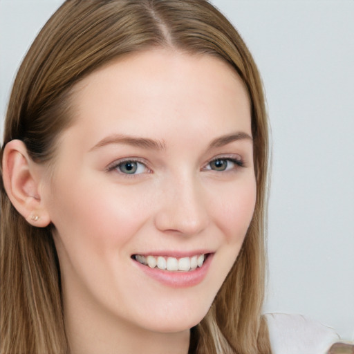 Joyful white young-adult female with long  brown hair and blue eyes