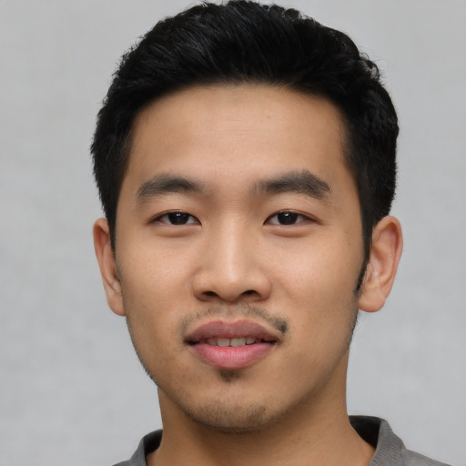 Joyful asian young-adult male with short  black hair and brown eyes