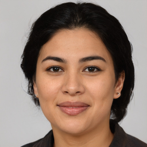 Joyful latino adult female with medium  brown hair and brown eyes