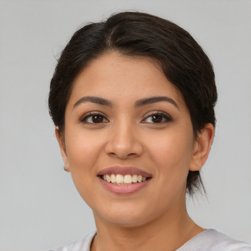 Joyful latino young-adult female with medium  brown hair and brown eyes