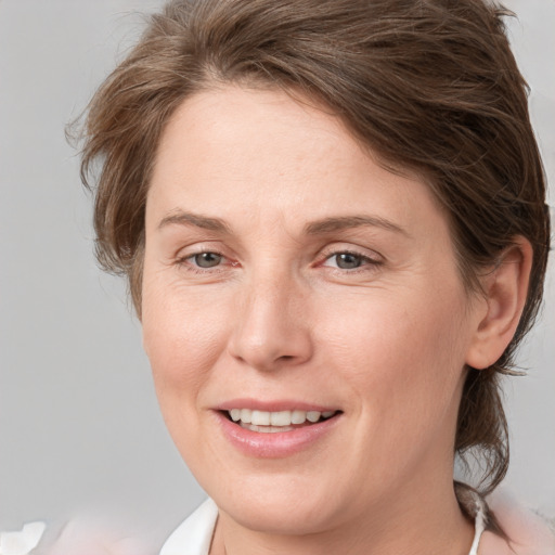 Joyful white adult female with medium  brown hair and grey eyes