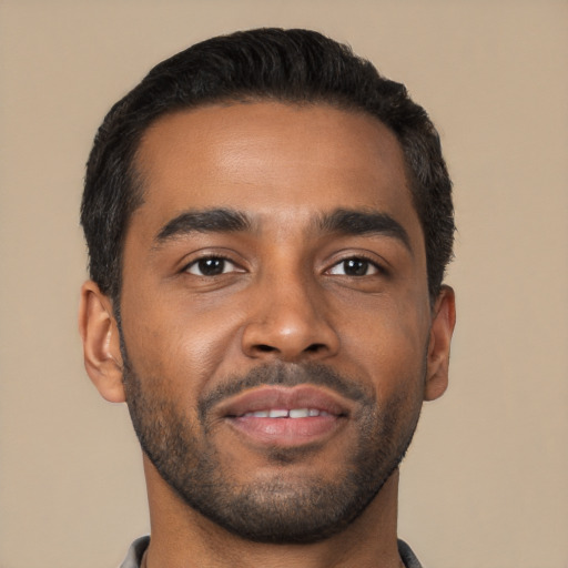 Joyful black young-adult male with short  brown hair and brown eyes