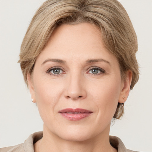 Joyful white adult female with medium  brown hair and grey eyes