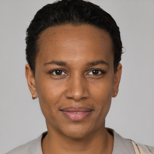 Joyful black young-adult female with short  black hair and brown eyes