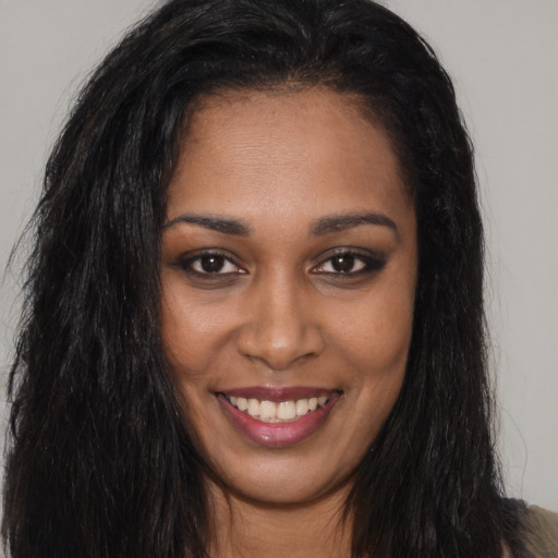 Joyful black young-adult female with long  brown hair and brown eyes