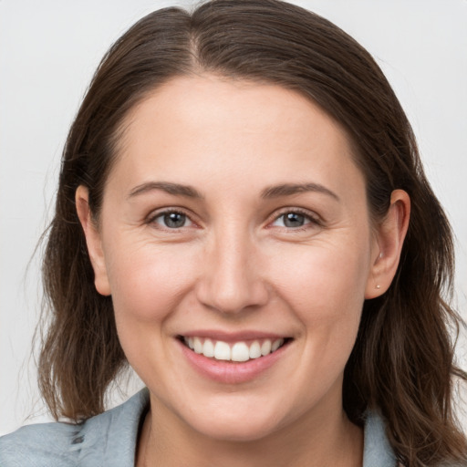 Joyful white young-adult female with long  brown hair and grey eyes