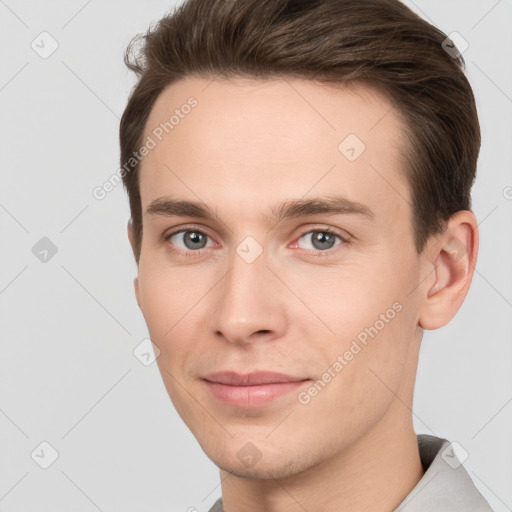 Joyful white young-adult male with short  brown hair and grey eyes