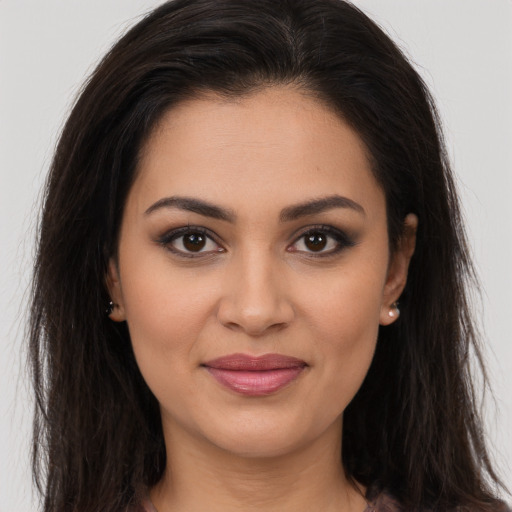 Joyful latino young-adult female with long  brown hair and brown eyes