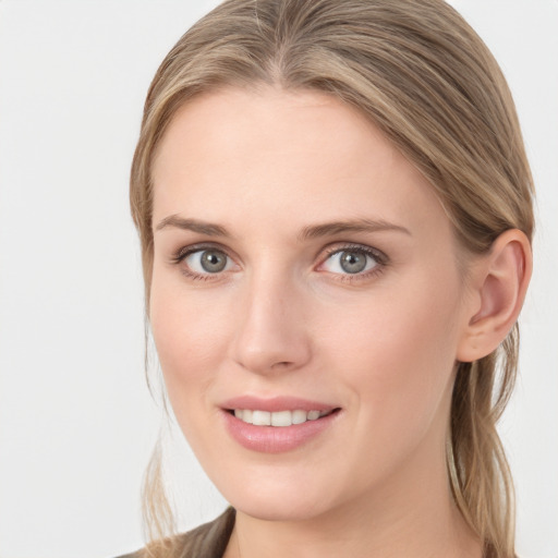 Joyful white young-adult female with long  brown hair and blue eyes