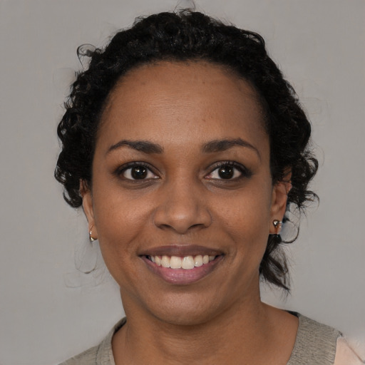 Joyful black young-adult female with medium  black hair and brown eyes