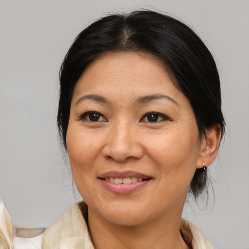 Joyful asian adult female with medium  brown hair and brown eyes