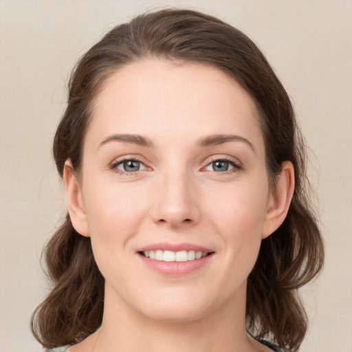 Joyful white young-adult female with medium  brown hair and green eyes