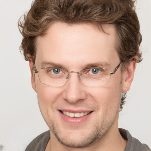 Joyful white adult male with short  brown hair and blue eyes