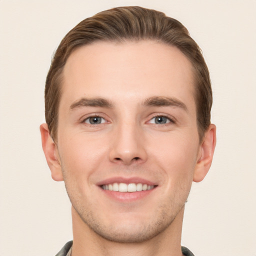 Joyful white young-adult male with short  brown hair and grey eyes