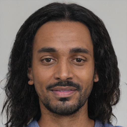 Joyful black young-adult male with medium  black hair and brown eyes