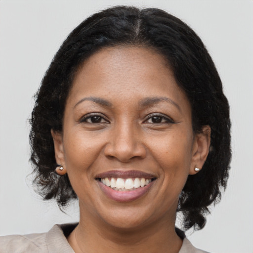 Joyful black adult female with medium  brown hair and brown eyes