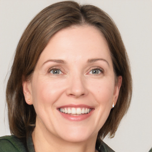 Joyful white adult female with medium  brown hair and grey eyes