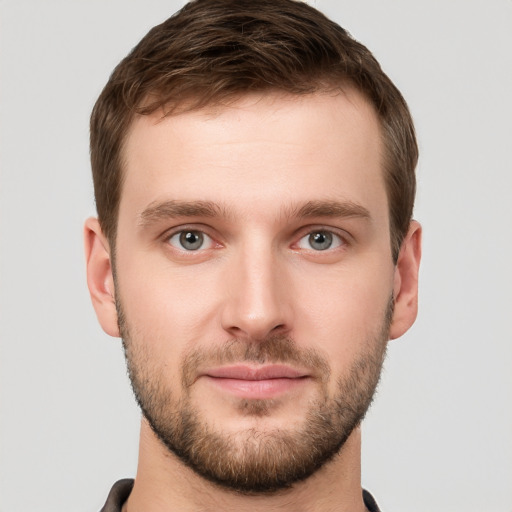 Joyful white young-adult male with short  brown hair and grey eyes